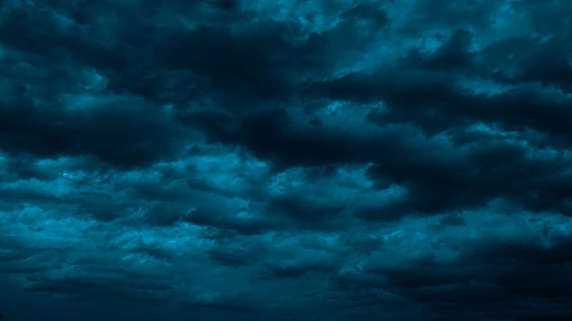 Night sky with clouds. Black dark petrol blue tone. Dramatic background. Storm thunder rain cloudy gloomy.
