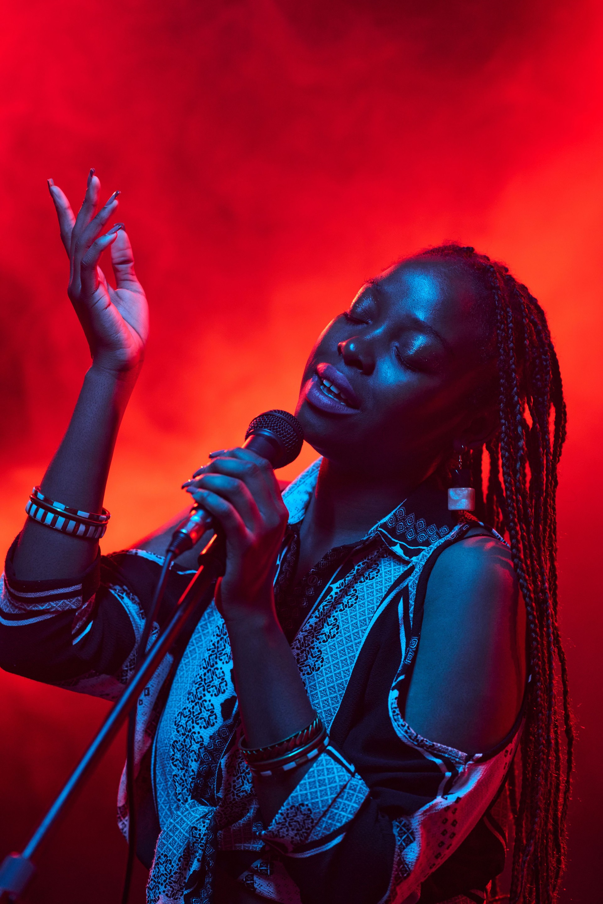 Black Woman Singing into Microphone on Stage with Smoke